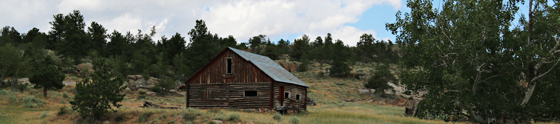 an old barn on a side of a hill